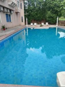 a large swimming pool with blue water at Sky villa with pool in Nāi