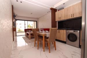 a kitchen and dining room with a table and a dishwasher at Marina plage in Kenitra +6 photos