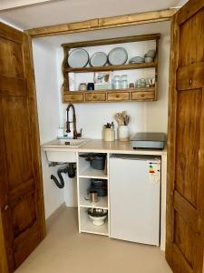 a kitchen with a sink and a white refrigerator at Dimora Palazzo De Luca - Intra Alborgodiffuso - Loft di Charme del 700 con Vasca doppia e Camino in Serracapriola