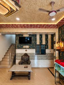 a living room with a couch and a tv on a wall at Bholenath Guest House 500 Mitter From Shree Ram Manidr in Faizābād
