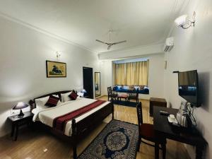 a bedroom with a bed and a desk and a television at Sky villa with pool in Nāi