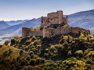 an old castle on a hill with mountains in the background at House-Evasion in Tuchan