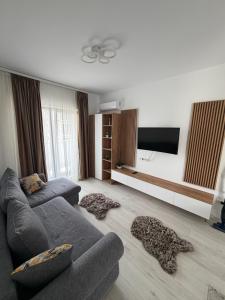 a living room with a couch and a flat screen tv at Apartment in Ploiești 4 in Ploieşti +5 photos