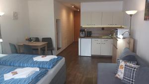 a room with two beds and a kitchen with a table at App MAJA Am Predigtstuhl in Sankt Englmar