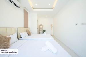 two beds in a room with white walls at Scarlet Poolvilla Pattaya in Na Jomtien +17 photos