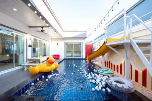 a pool with a slide and rubber ducks in a room at Scarlet Poolvilla Pattaya in Na Jomtien