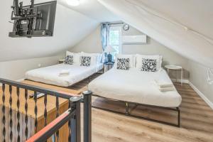 two beds in a room with a staircase at Where Classic Charm Meets Modern Serenity in Pittsburgh