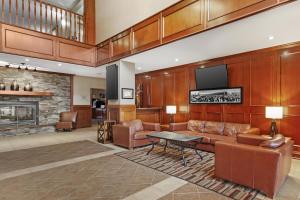 a living room with leather furniture and a fireplace at Best Western Plus Meridian in Lloydminster