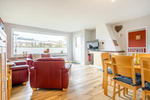 a living room with a table and chairs and a kitchen at Bungalow Hohes Riff in Norddeich