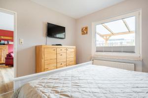 a bedroom with a bed and a tv and a window at Bungalow Hohes Riff in Norddeich