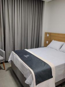 a hotel room with a bed and a chair at Hotel do Catarina in Rio Bonito