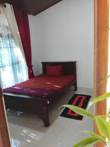a bed sitting in a room next to a window at Luuna'S Hostel Sigiriya in Sigiriya