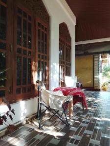 a room with a table and a chair on a porch at Luuna'S Hostel Sigiriya in Sigiriya +6 photos