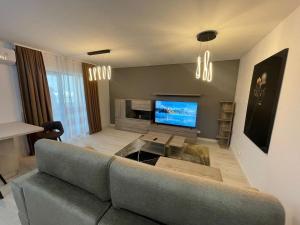 a living room with a couch and a tv at Apartment in Ploiești 5 in Ploieşti