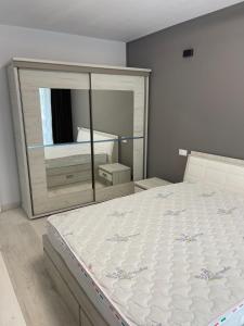 a bedroom with a large bed and a mirror at Apartment in Ploiești 5 in Ploieşti