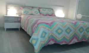 ログローニョにあるApartamento Gran Via Logroñoのベッドルーム1室(カラフルな掛け布団付きのベッド1台付)