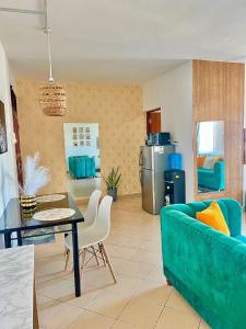 a living room with a blue couch and a table at tabby stays one bedroom with two beds bamburi in Mombasa