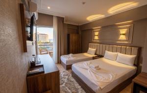 a hotel room with two beds and a window at Park Marina Hotel in Kemer
