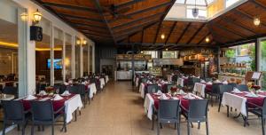 a dining room with tables and chairs in a restaurant at Park Marina Hotel in Kemer
