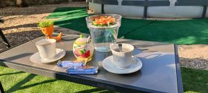 a table with a vase of flowers and cups on it at Villa Oasis in Los Gallardos