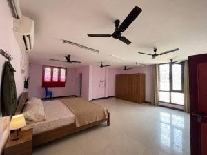 a bedroom with a bed and two ceiling fans at Hotel Bypass in Madurai