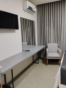 a hospital room with a desk and a chair at Hotel do Catarina in Rio Bonito
