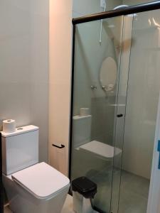 a bathroom with a toilet and a glass shower at Hotel do Catarina in Rio Bonito