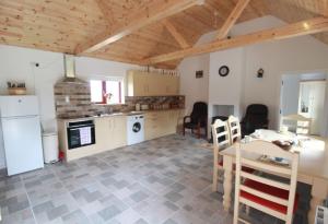 a kitchen and dining room with a table and chairs at Historic Louisburgh Farm Cottage in Louisburgh +7 photos