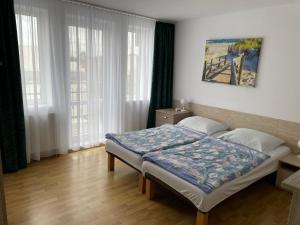 a bedroom with a bed in a room with windows at Pensjonat Anna in Osłonino