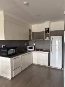 a kitchen with white cabinets and a white refrigerator at Departamento en Goya Ctes in Goya