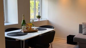 a dining room table with a bottle of wine and chairs at Arya villa in Bergen +16 photos