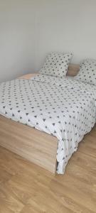 a bed in a room next to a wooden floor at Appartement 2 Ch la Romagne in La Romagne
