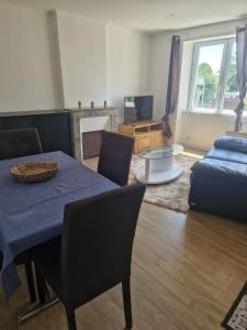 a living room with a blue table and a couch at Appartement 2 Ch la Romagne in La Romagne +6 photos