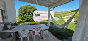 a table and chairs under a porch with a trailer at Casita Costa in Miengo +2 photos