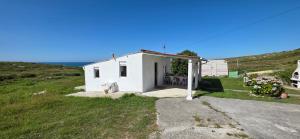 a small white building on a grassy hill at Casita Costa in Miengo
