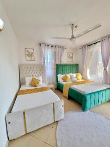 two beds sitting in a room with two windows at tabby stays one bedroom with two beds bamburi in Mombasa