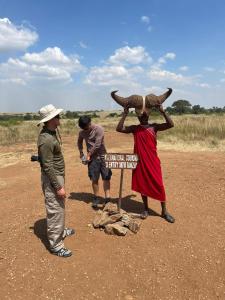 a group of people standing around a sign in the desert at Empiris Lodge in Sekenani +20 photos