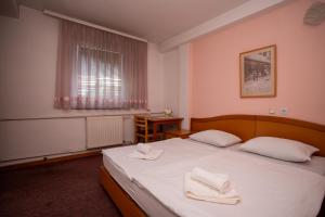 a bedroom with a bed with two towels on it at Hotel Ferijalac in Sarajevo +34 photos