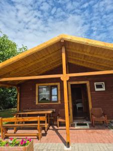 a cabin with a picnic table and a wooden roof at Dom pod lipą in Łeba