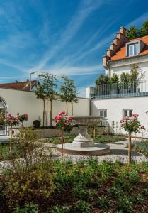 a garden with a fountain in front of a building at Schloss am Bodensee I Private Sauna & Whirlpool in Stockach