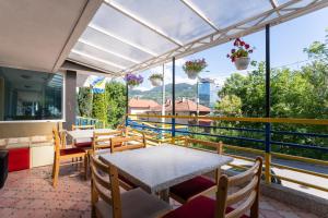 a balcony with a table and chairs and windows at Hotel Ferijalac in Sarajevo