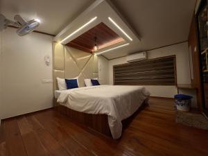 a bedroom with a large bed with white sheets and blue pillows at Navora Houseboats in Alleppey