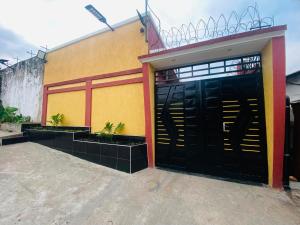 a building with two black garage doors and plants at Résidence moncloa in Brazzaville