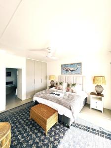 a bedroom with a large bed and a table at House Charisma in Britannia Bay