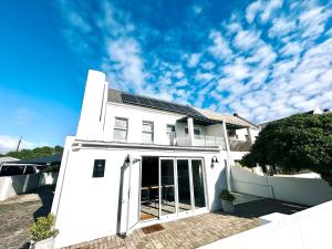 a white house with solar panels on it at House Charisma in Britannia Bay