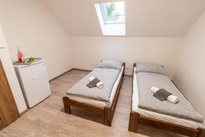 two beds in a small room with a window at Búda u Kramářů - penzion Robin in Mutěnice
