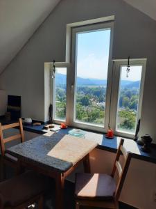 a dining room with a table and two windows at Wohnung in einer kleinen Burg in Neunkirchen