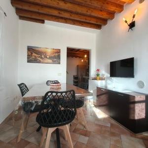 a dining room with a table and chairs and a television at Tuscan Sunsets Tramonti Toscani in Fauglia
