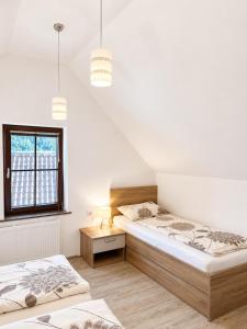 a bedroom with two beds and a window at Apartmaji Kramar Rateče in Kranjska Gora