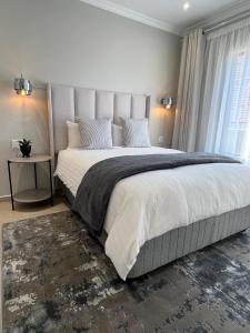 a bedroom with a large bed with a large window at Zahari Villas in Parys